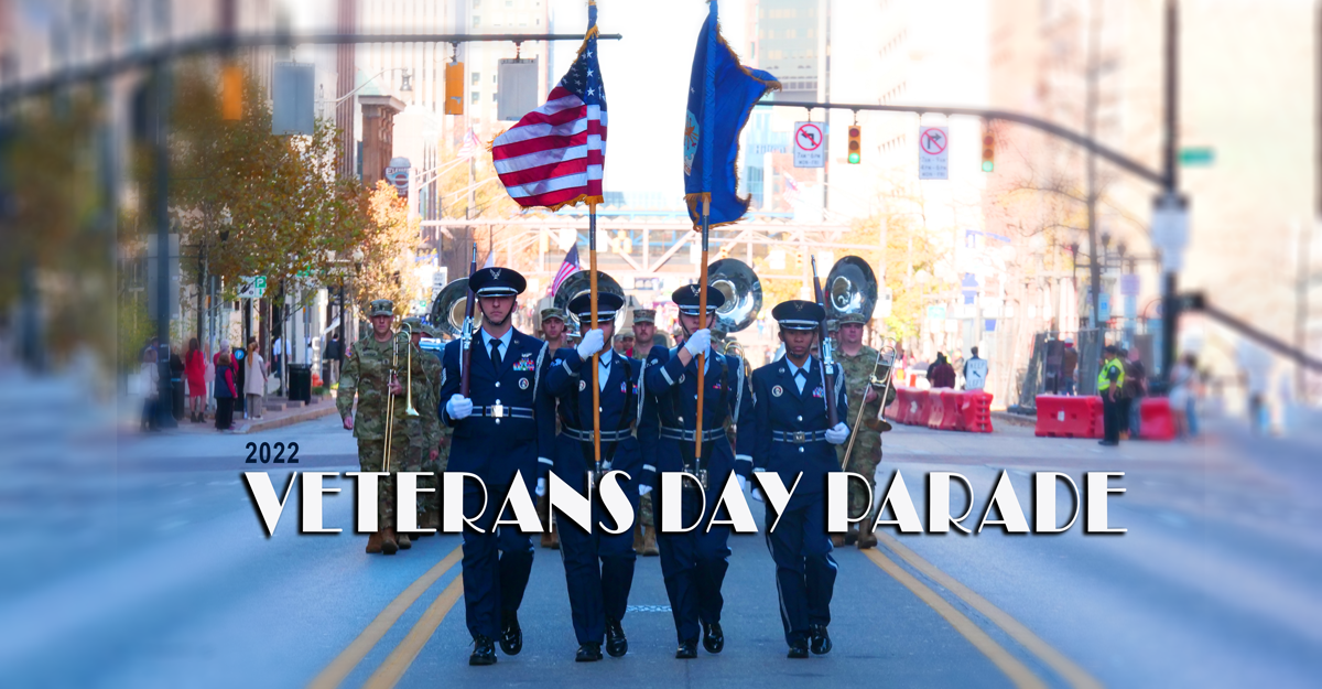 Color guard carries flags in street during parade.