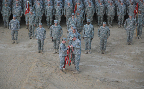 Lt. Col. Tom Caldwell (foreground, left) commander of the 216th Engineer Battalion, and Battalion Command Sgt. Maj. Steven Shepherd affix a campaign streamer to the battalion's organizational colors June 15, 2011