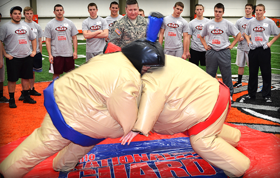 Ohio Army National Guard Recruiting and Retention Battalion 1st Sgt. David Hunt referees as two high school football players wrestle, while wearing sumo suits