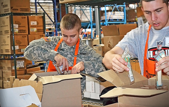 Ohio National Guard Soldiers volunteer beside high school football players March 29, 2013, at the Cleveland Foodbank
