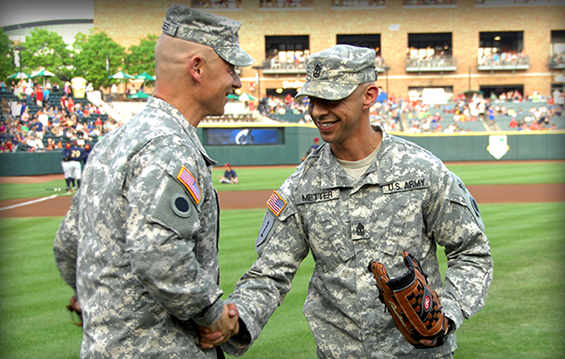 Ohio Army National Guard Command Sgt. Maj. Rodger M. Jones (left) shakes hands with 1st Sgt. Matthew Metter after Metter threw the opening pitch to Jones before a Columbus Clippers baseball game May 18, 2013.