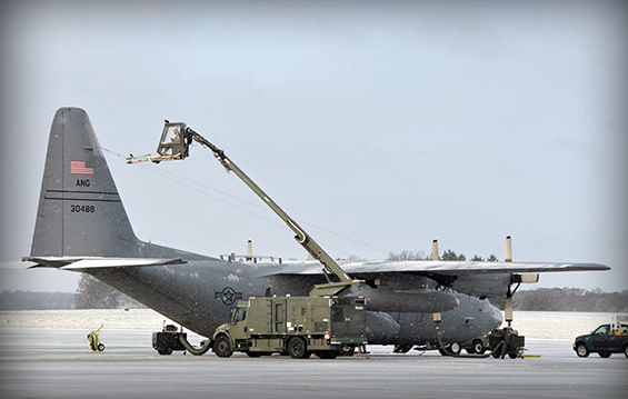 Airmen work to de-ice one of the C-130H Hercules cargo aircraft  on a snowy winter day at the 179th Airlift Wing in Mansfield, Ohio.