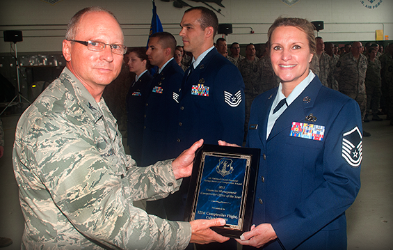 Col. James Jones (left), 121st Air Refueling Wing commander, presents Master Sgt. Susan Rowland with the 2013 Financial Management Comptroller Office of the Year award.
