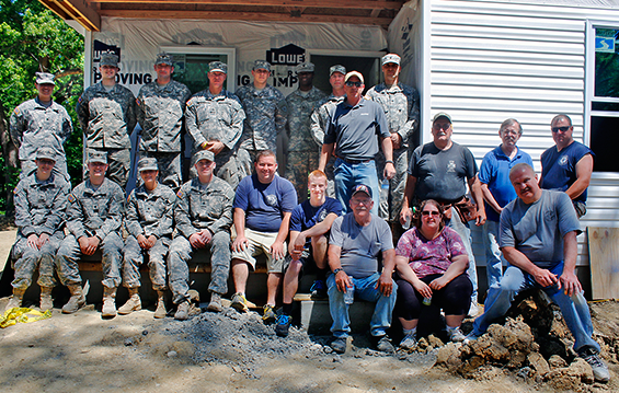 Soldiers from Company B (Detachment 1), 638th Support Battalion (Aviation Support), along with members of the Sebring Fire Department and Veterans of Foreign Wars Post 6730, stand in front of the home they built for Habitat for Humanity.