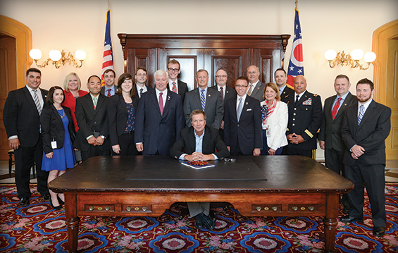 Ohio Gov. John Kasich (seated) is joined by state legislators and cabinet agency representatives, including Brig. Gen. John C. Harris Jr., (third from right) Ohio assistant adjutant general for Army