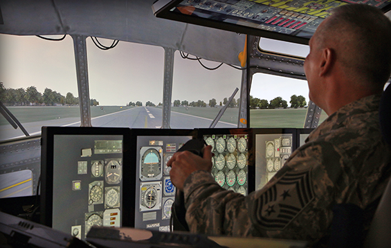 Chief Master Sgt. Philip D. Smith, Ohio Air National Guard command chief, operates the Multi-Mission Crew Trainer, a C-130H Hercules flight simulator.