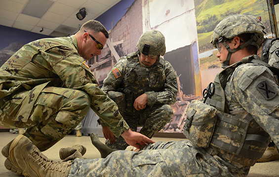 Sgt. Todd Turner (center), a health care sergeant with Headquarters and Headquarters Detachment, 155th Chemical Battalion, Ohio Army National Guard, is instructed on proper bandaging of a wound during a medical training course