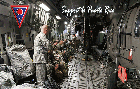 Soldiers with 1st Battalion, 137th Aviation Regiment sit alongside two UH-60 Black Hawk helicopters loaded in a C-17 Globemaster III.