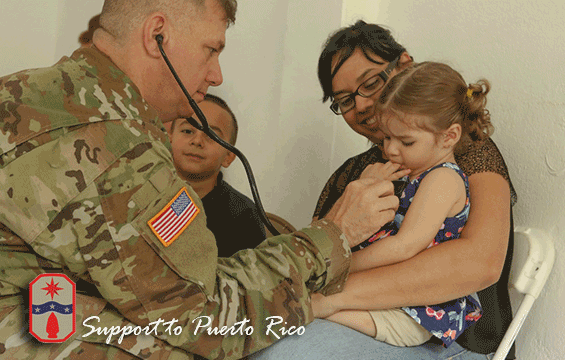 Maj. Donald McHone (left), a registered nurse with the 285th Medical Company (Area Support), uses a stethoscope to listen to the breath and heart sounds of a young girl.