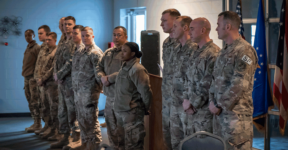 Group Airmen stand in line in front of room