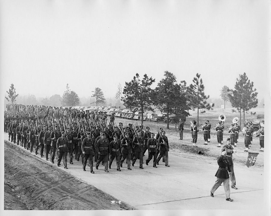 Black and white photo of Soldiers marching in road from 1941.