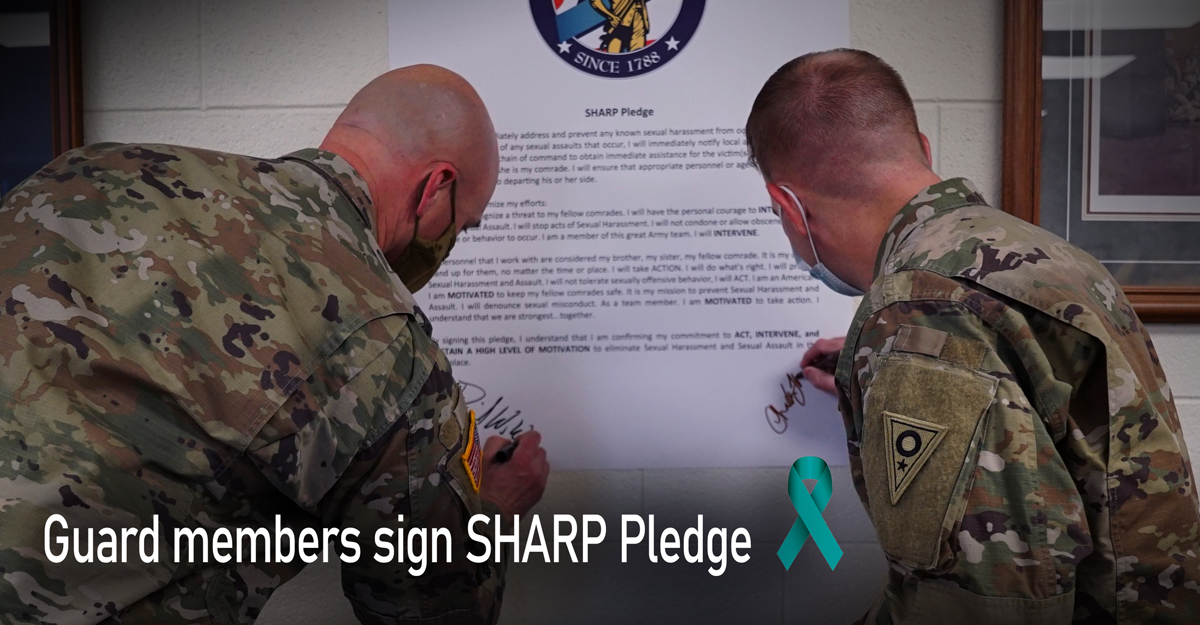 Male solders sign pledge on wall.