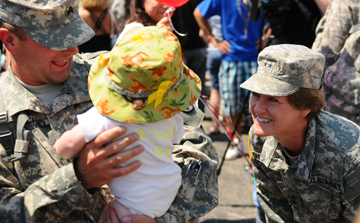 Sgt. Roy Mitchell (left), of the Ohio Army National Guard's 292nd Engineer Detachment, holds his son, Roy Mitchell IV, as Maj. Gen. Deborah Ashenhurst, Ohio adjutant general, coaxes a smile from the weeks-old infant 