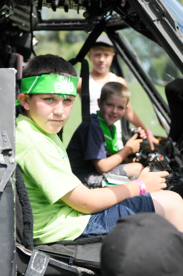 Sitting in the cockpit of a UH-60 Black Hawk helicopter, George Gibbons (left), of Orient, Ohio, and other children from military Families participate in Operation Military Kids Camp