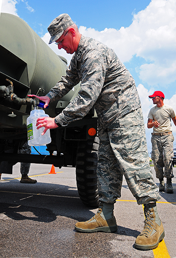Maj. Gen. Mark E. Bartman, Ohio assistant adjutant general for Air, fills up container with water for distribution.