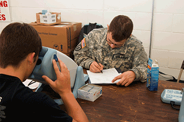 Spc. Nathaniel Lee, a health care specialist with the Ohio Army National Guard Medical Detachment, annotates a patient’s chart during an eye exam.