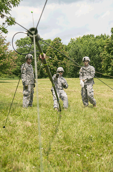 Cpl. Tyler Long (from left), Capt. Matthew Curtis and Spc. Alan Shirer raise a communications antenna for the construction of a hasty tactical command post.