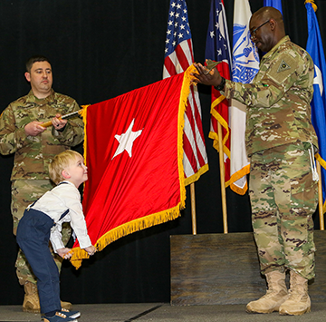 Sam Stivers helps unfurl a new one-star flag for his father, newly promoted Brig. Gen. Steven E. Stivers.