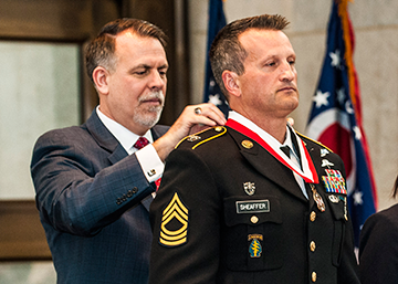 Retired Col. Chip Tansill (left), director of the Ohio Department of Veterans Services awards Master Sgt. Matthew R. Sheaffer with a medal signifying his induction into the Ohio Military Hall of Fame for Valor. 