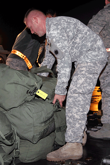 Soldiers with the 137th Signal Company, based in Newark, Ohio, unload their gear from a KC-135 Stratotanker.