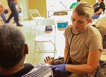 Spc. Tessa Kolman, a medic with the 285th Medical Company (Area Support), checks the vital signs of a Puerto Rican citizen.