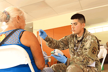 Pfc. Victor Guerrero, a medic with the 285th Medical Company (Area Support), assesses a patient .