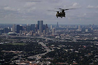 An Ohio Army National Guard CH-74 Chinook helicopter flies near downtown Houston this weekend. The Army National Guard is using helicopters to drop hay for cattle stranded in flooded areas near Beaumont. Over a week after Hurricane Harvey hit Southern Texas, residents are beginning the long process of recovering from the storm. 