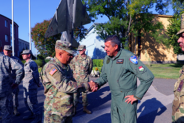 Two men shake hands outside Air Base.