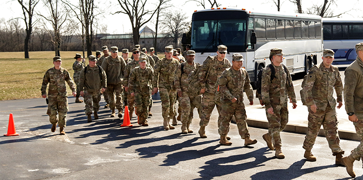 Soldiers from the 371st Sustainment Brigade file off buses.