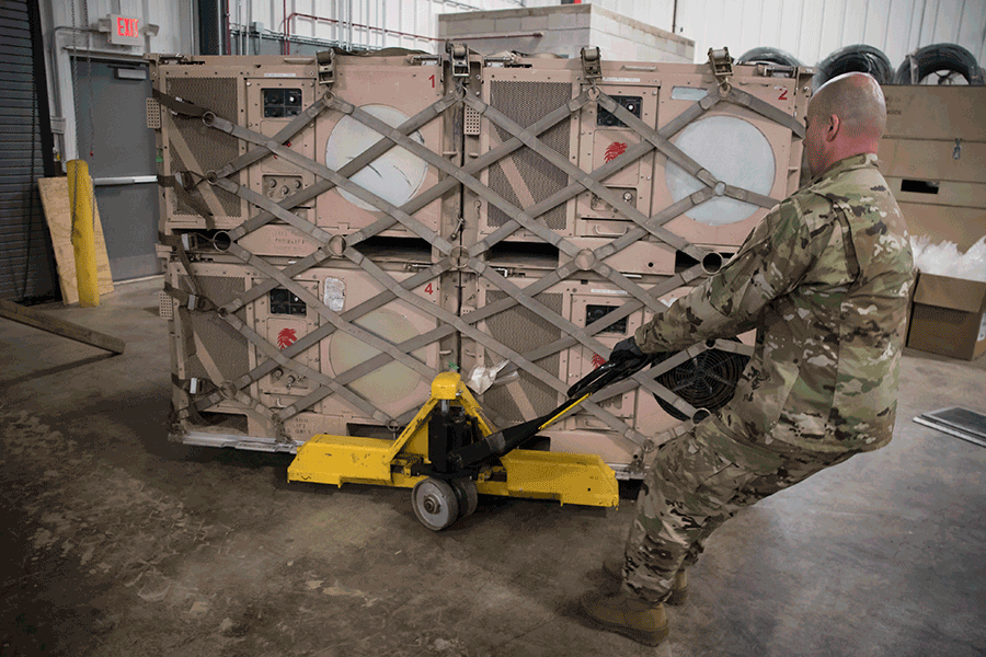 Airman uses handcart to pull pallet to be loaded for transport.