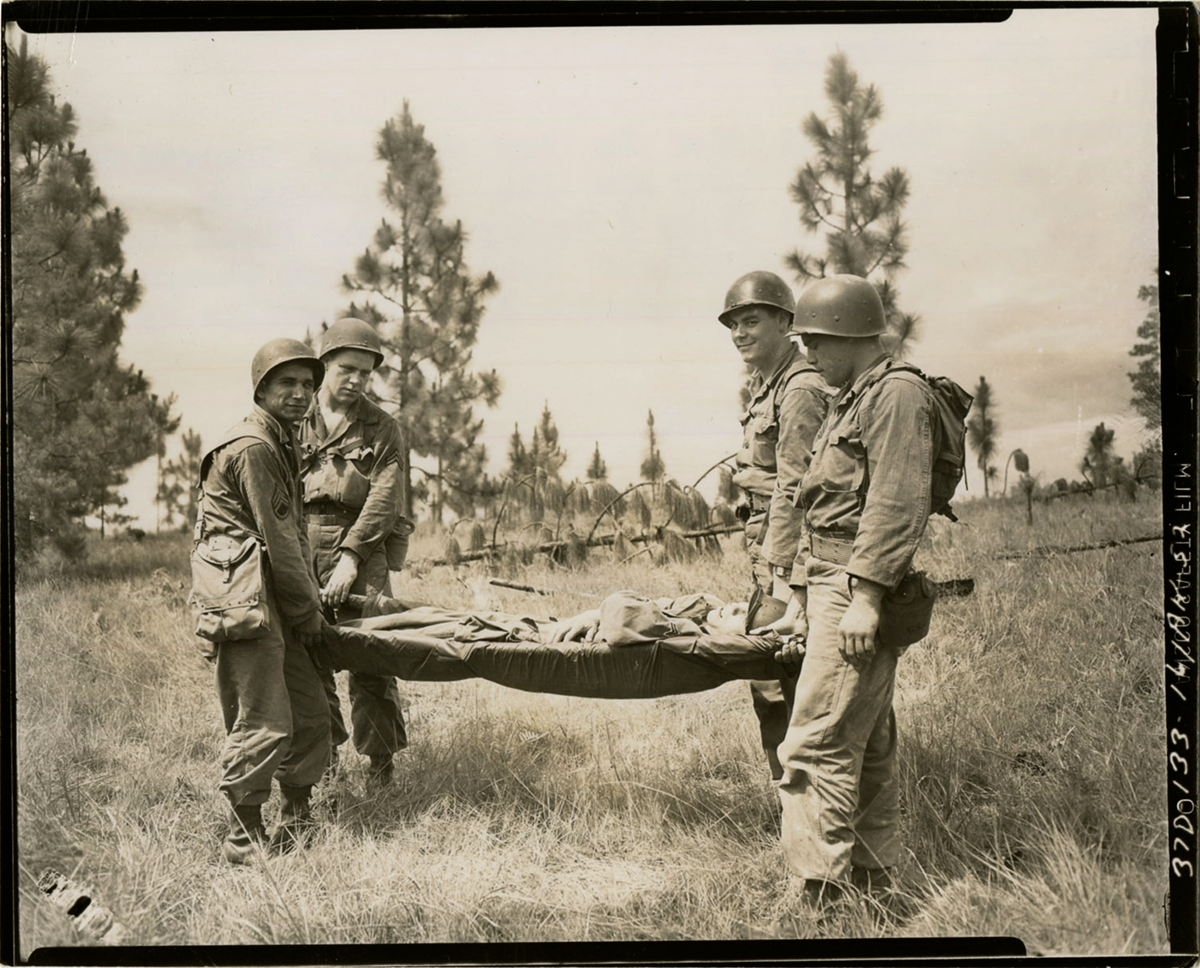 Sepia tone of Soldiers carrying injured Soldier off field on a gurney