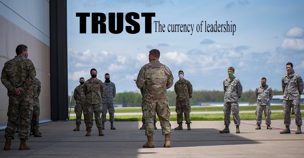 TRUST: The currency of leadership. BG Camp addressesgroup of airmen outside, social distancing, wearing ppe.