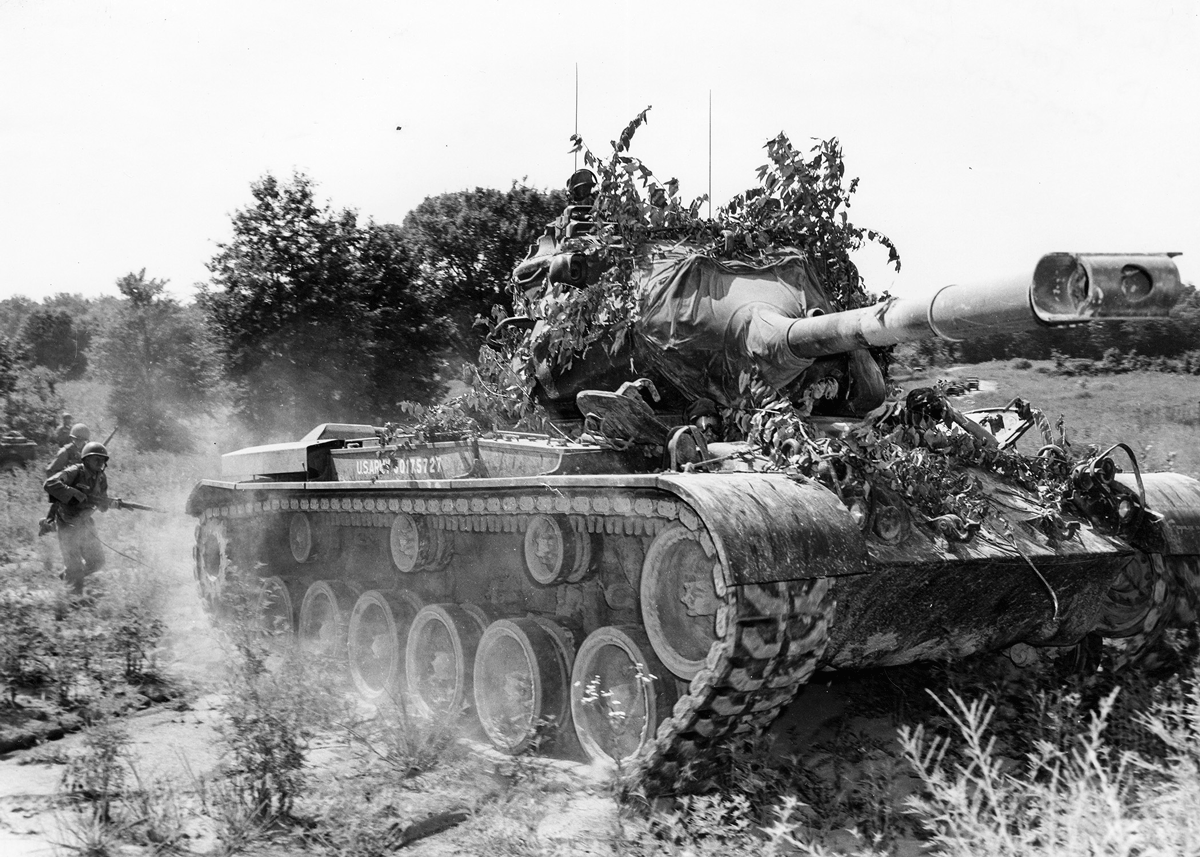 Soldier behind tank.