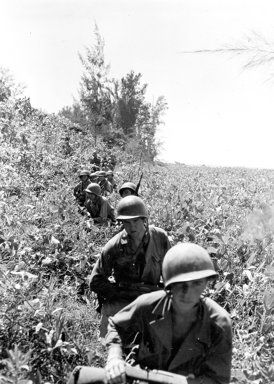Soldiers marching through tall grass