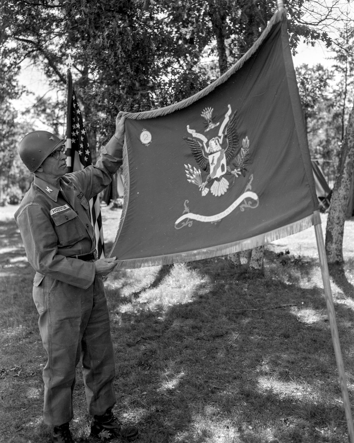 Colonel displaying flag in forest.