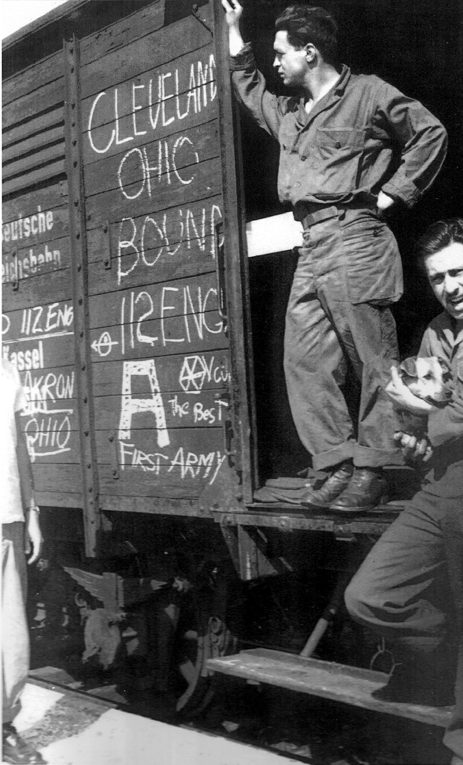 A Soldier stands in the door of a rail car marked 'Cleveland Ohio Bound'
