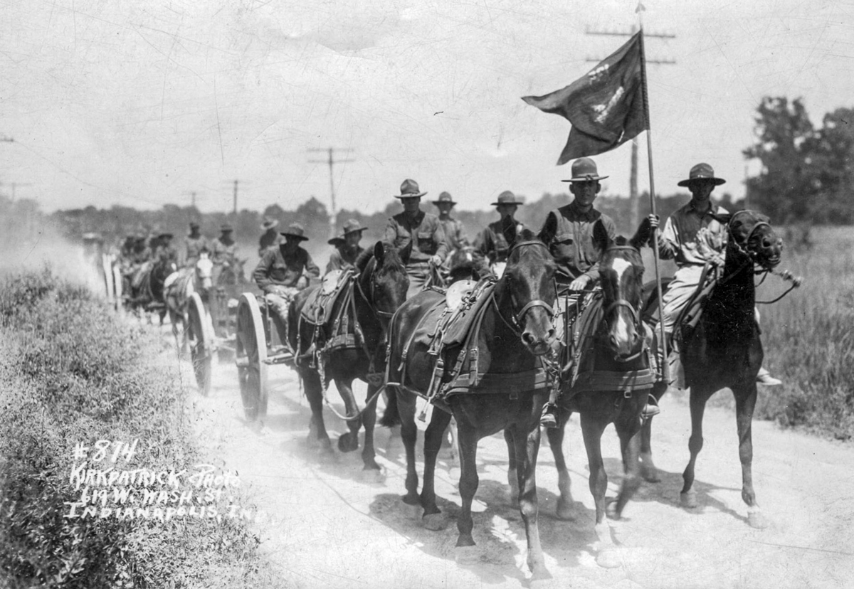 Soldiers on horses on road.
