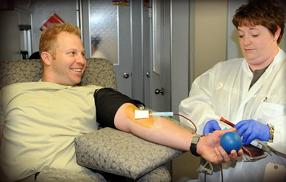Staff Sgt. Cody Albright (left), a member of the121st Air Refueling Wing Fire Department at Rickenbacker Air National Guard Base in Columbus, Ohio, takes time out during drill weekend on July 28, 2013, to donate blood.