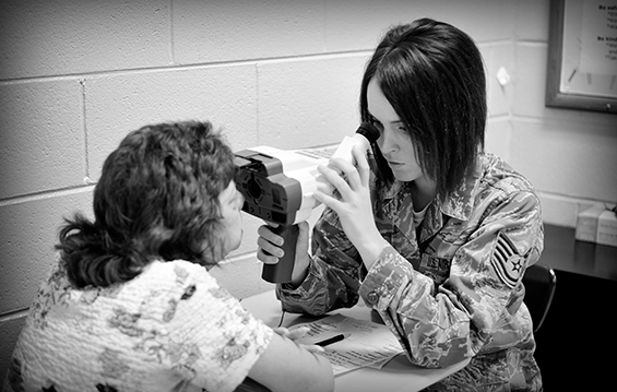 Tech Sgt. Kaitlyn Conner (right), a laboratory technician with the 180th Fighter Wing, located in Toledo, Ohio, conducts a vision test July 15, 2013, at Martin Middle School in Martin, Tenn.