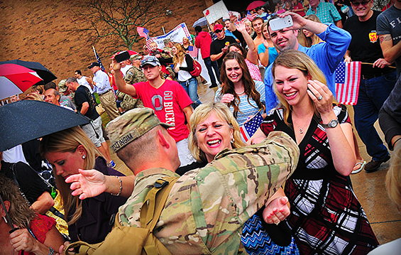 First Lt. Robert T. Cottingim of the 1487th Transportation Company is greeted by Family and friends as he dismounts a bus before the unit's welcome home ceremony on Oct. 4, 2013, at Piqua High School in Piqua, Ohio. 