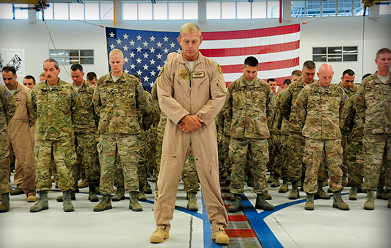 Airmen of the 180th Fighter Wing bow their heads during a welcome home ceremony 
