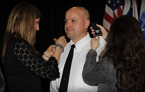 Col. Ben Capriato (center), 16th Engineer Brigade commander, receives his eagle O-6 rank shoulder epaulettes from his wife, Shannon (left), and daughter, Amanda.
