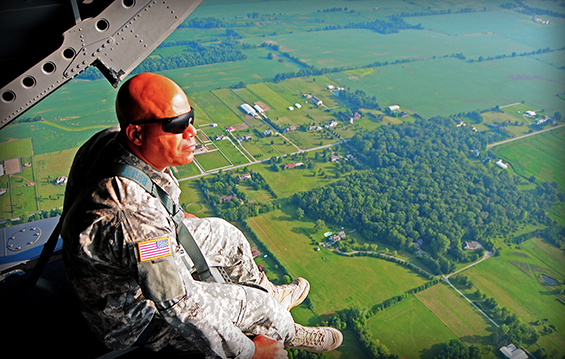 Brig. Gen. John C. Harris Jr., Ohio assistant adjutant general for Army, surveys the landscape below while strapped on to the back ramp of an Ohio Army National Guard CH-47 Chinook helicopter. 