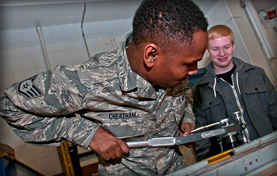 Staff Sgt. Dante Cheatham (left), of the 179th Airlift Wing, demonstrates some mechanical tools engineered for the aviation field to Crestview High School sophomore Sam Richards.