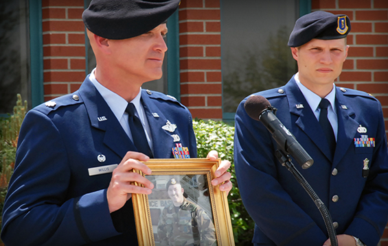 Lt. Col Bernard Willis, 178th Wing Security Forces Squadron commander, honors Master Sgt. Michael Harmon at the Harmon Hall rededication ceremony.
