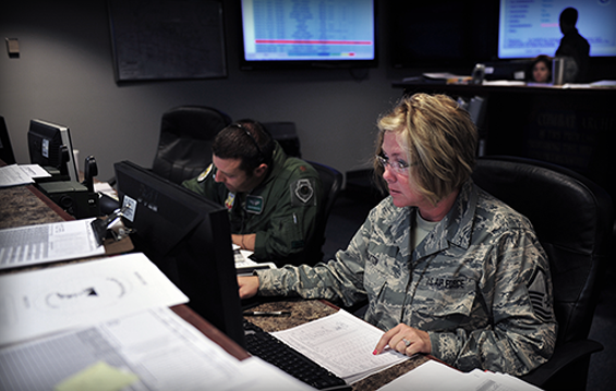 Master Sgt. Jamie Paxton (right), an aviation resource management specialist, and Maj. Gregory Barasch, an F-16 fighter pilot, both with the 180th Fighter Wing, load flight authorizations before training sorties.