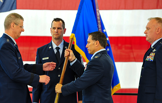 Col. Craig Baker (third from left), outgoing commander of the 180th Fighter Wing, passes the unit flag to Maj. Gen. Mark E. Bartman (left), Ohio adjutant general, during a change of command ceremony.