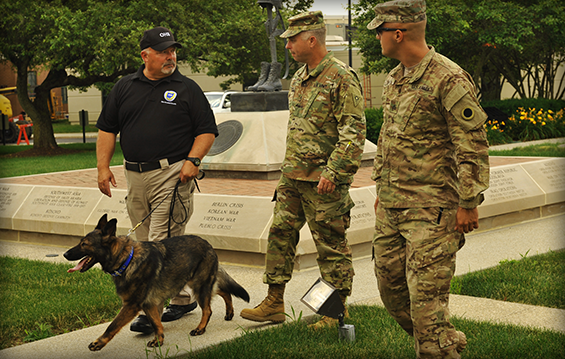 Sgt. Benjamin Smith (from right) and Master Sgt. Michael Buck, both with the Ohio National Guard Force Protection, Anti-Terrorism and Physical Security Team, meet with Mike Palumbo, a dog handler with the Ohio Department of Public Safety-Ohio Homeland Security and Chloe, an explosive detection canine.