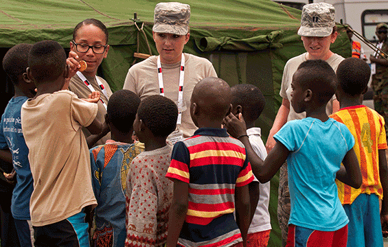 Ohio National Guard Members pass out snacks to children in the village of Ceramica.