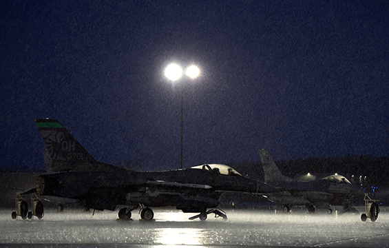 An F-16 Fighting Falcon sits on the flight line during a spring storm.